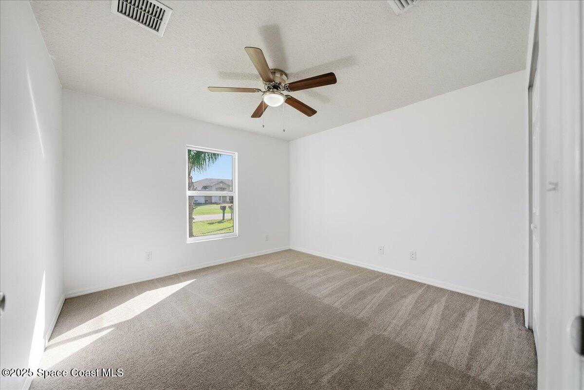 6424 Muller Avenue Cocoa, FL 32927 - Photo 21 of 33 an empty room with windows and fan