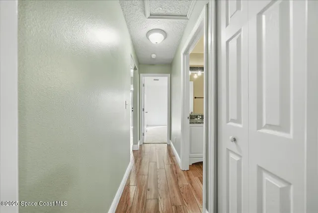a view of a hallway with wooden floor and entryway