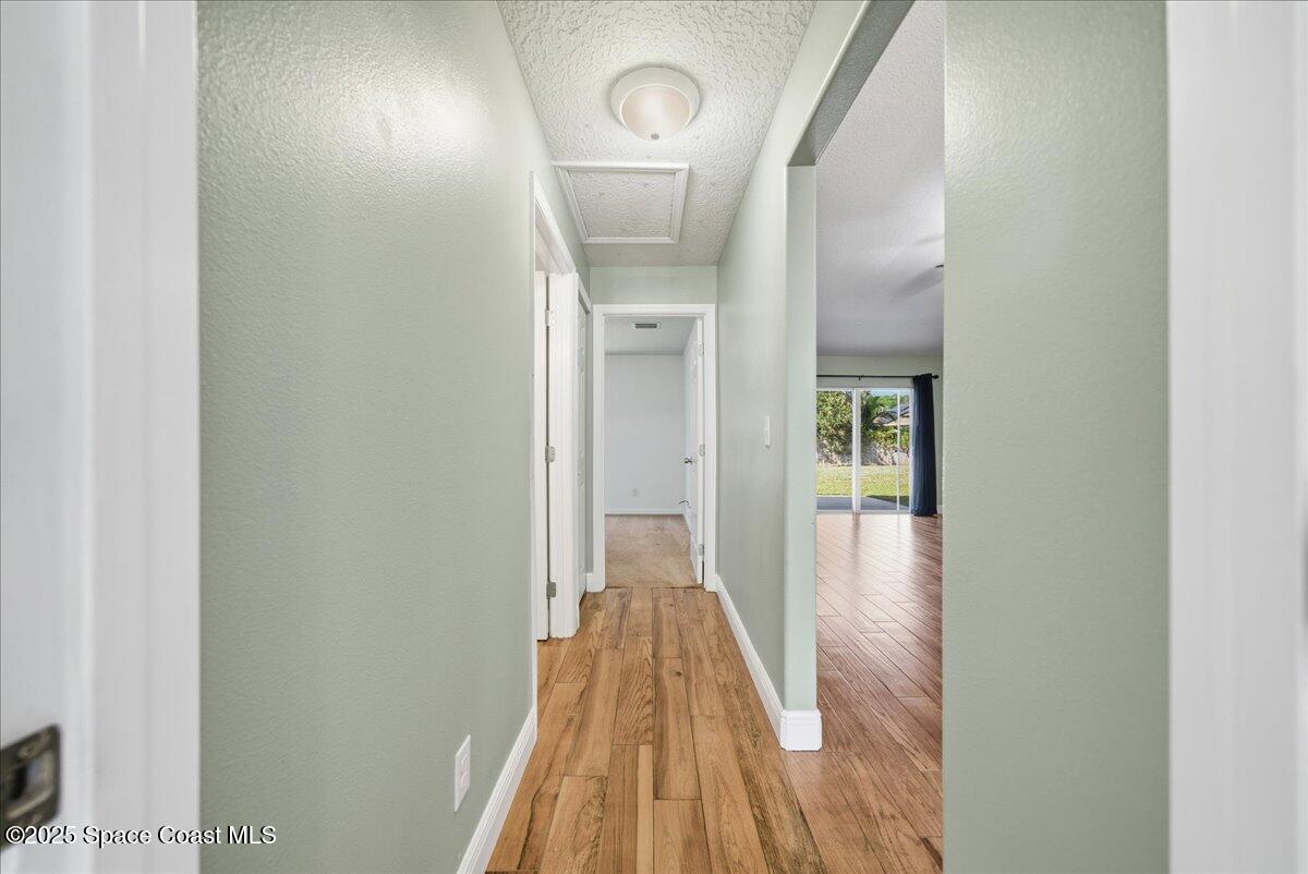 6424 Muller Avenue Cocoa, FL 32927 - Photo 23 of 33 a view of a hallway with wooden floor and a bathroom