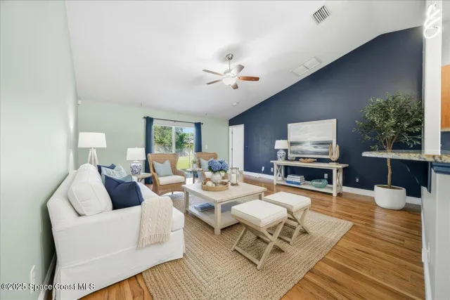 a living room with furniture a chandelier and a table