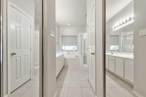 a bathroom with a glass shower door a sink and a mirror