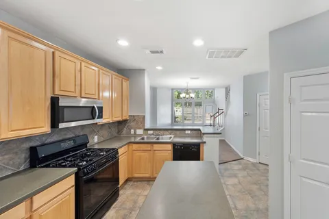 a kitchen with stainless steel appliances granite countertop a stove a sink and a microwave