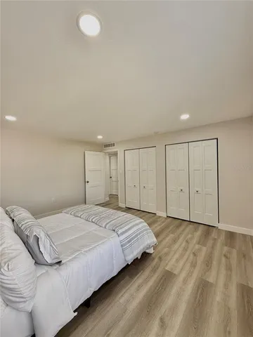 a spacious bedroom with a bed and a cabinets