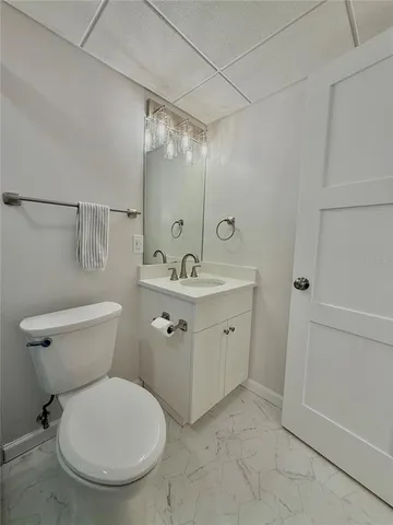 a bathroom with a granite countertop toilet sink and mirror