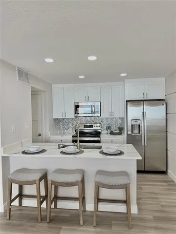 a kitchen with white cabinets and stainless steel appliances
