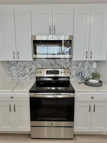 a stove top oven sitting inside of a kitchen