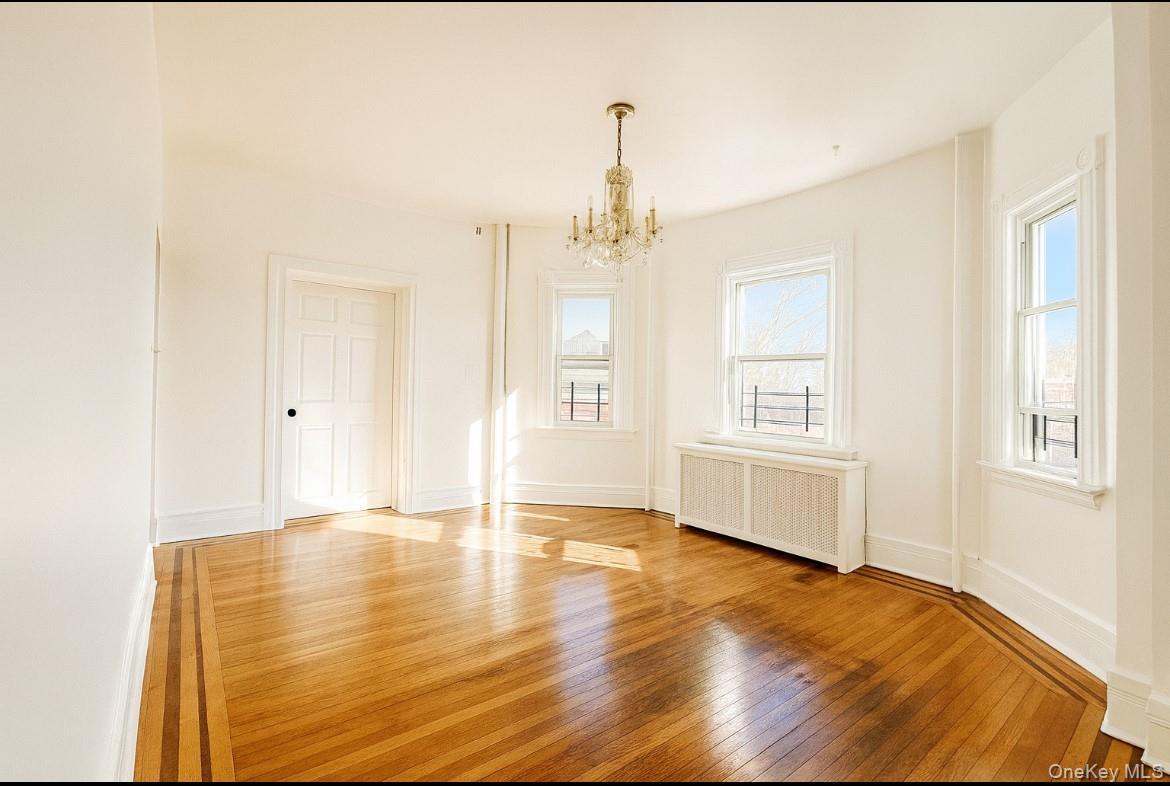 194 Summit Avenue, Unit 2 Mount Vernon, NY 10550 - Photo 17 of 19 Unfurnished dining area with hardwood / wood-style floors, radiator heating unit, and a chandelier