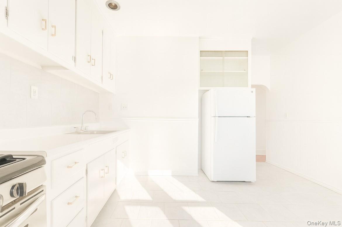 194 Summit Avenue, Unit 2 Mount Vernon, NY 10550 - Photo 3 of 19 Kitchen featuring freestanding refrigerator, light countertops, range with gas stovetop, and white cabinetry