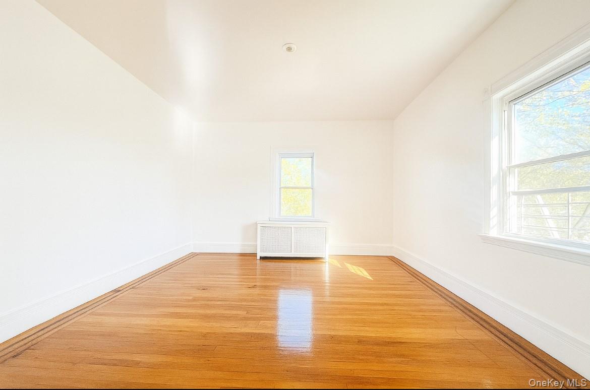 194 Summit Avenue, Unit 2 Mount Vernon, NY 10550 - Photo 10 of 19 Empty room with radiator heating unit and light wood-type flooring