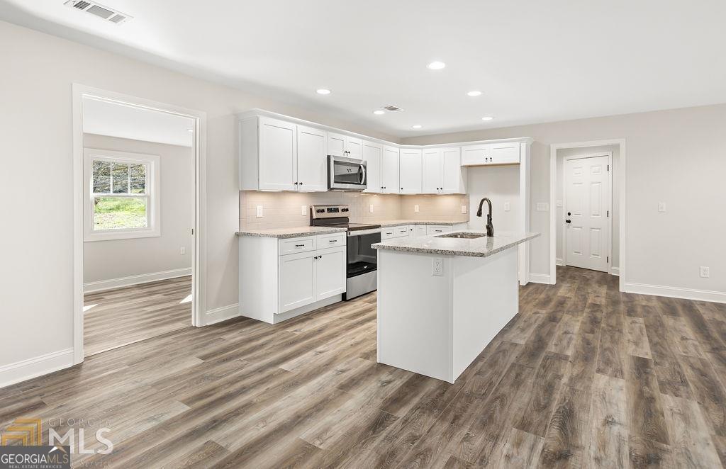 3077 Alec Mountain Road Clarkesville, GA 30523 - Photo 16 of 35 a kitchen with stainless steel appliances granite countertop a stove top oven a sink dishwasher and a refrigerator