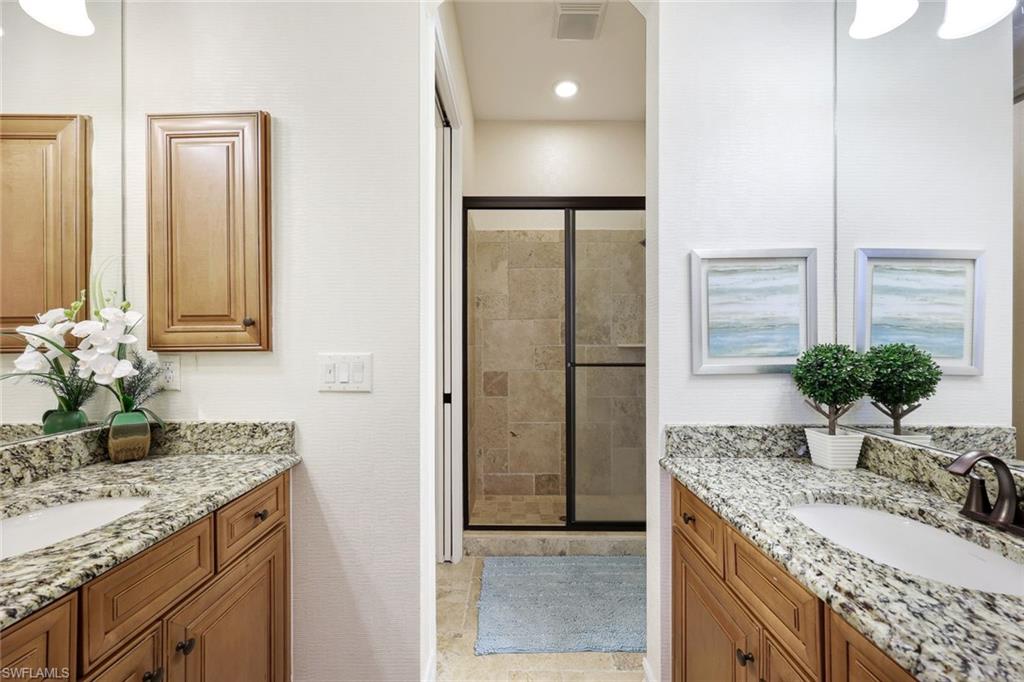 9856 Corso Bello Drive Naples, FL 34113 - Photo 20 of 50 a bathroom with a granite countertop sink and a mirror