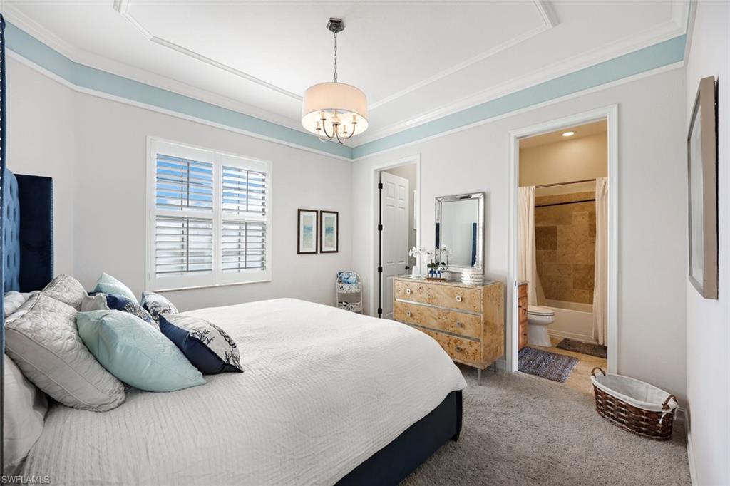 9856 Corso Bello Drive Naples, FL 34113 - Photo 22 of 50 a bedroom with a bed and a chandelier