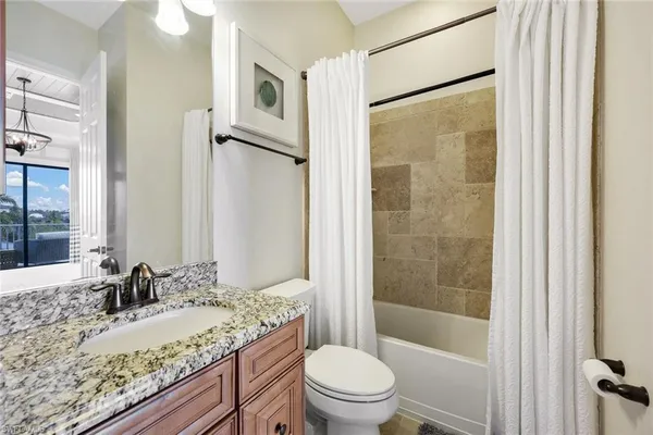a bathroom with a granite countertop sink toilet and shower