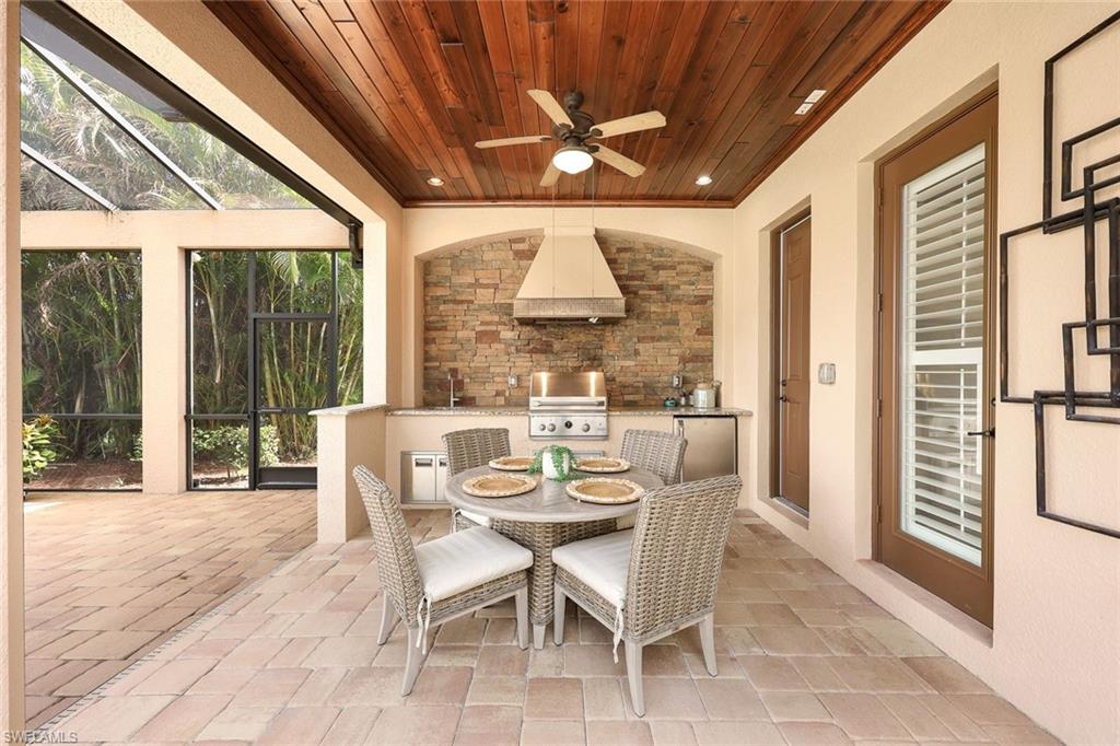9856 Corso Bello Drive Naples, FL 34113 - Photo 26 of 50 a dining room with furniture large windows and a chandelier