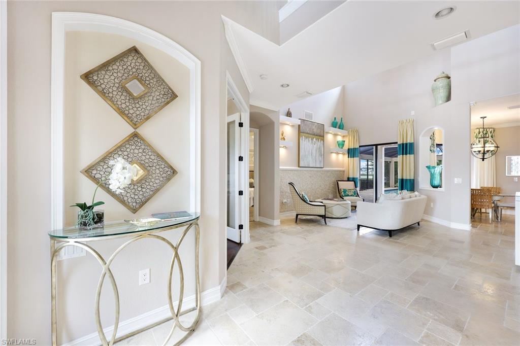9856 Corso Bello Drive Naples, FL 34113 - Photo 6 of 50 a living room with furniture and a clock