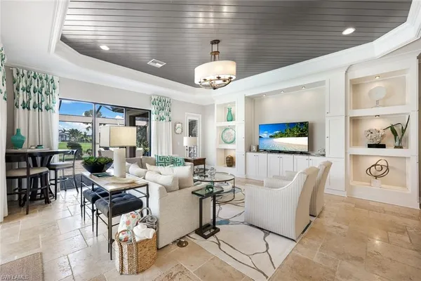 a living room with couches a fireplace and a dining table with wooden floor