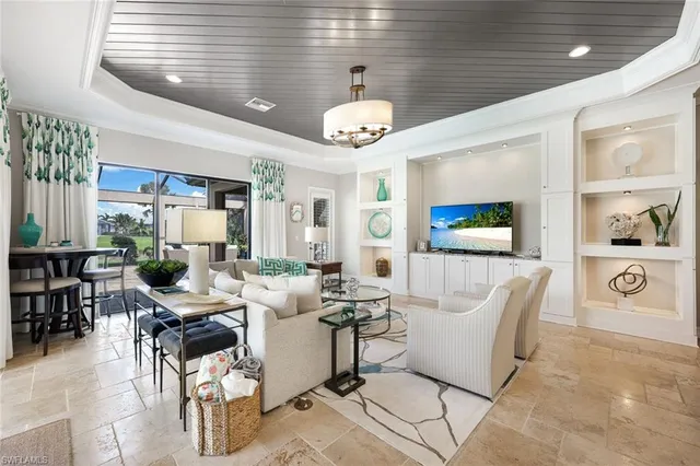 a living room with couches a fireplace and a dining table with wooden floor