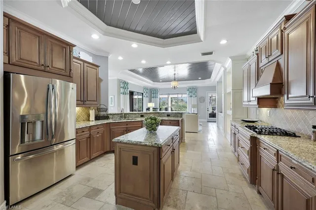 a kitchen with stainless steel appliances granite countertop a refrigerator a stove a sink and a refrigerator