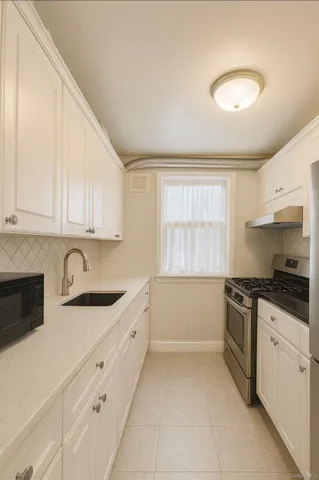 a kitchen with granite countertop white cabinets and white appliances