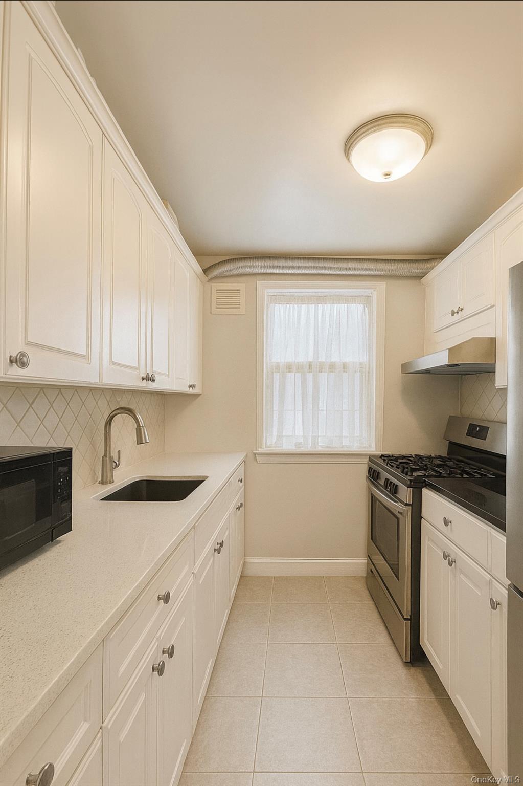 150-40 Jewel Avenue, Unit 66B Queens, NY 11367 - Photo 5 of 11 a kitchen with granite countertop white cabinets and white appliances