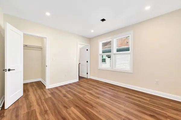 a view of a kitchen with wooden floor and a window