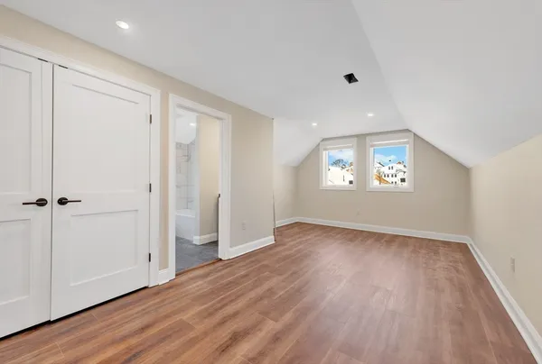 a view of a hallway with wooden floor and a living room