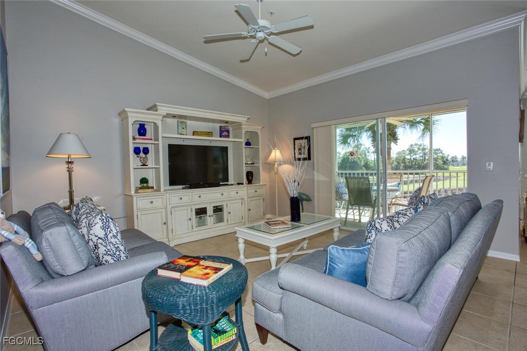 10371 McArthur Palms Lane, Unit 2823 Fort Myers, FL 33966 - Photo 3 of 48 a living room with furniture a flat screen tv and a large window
