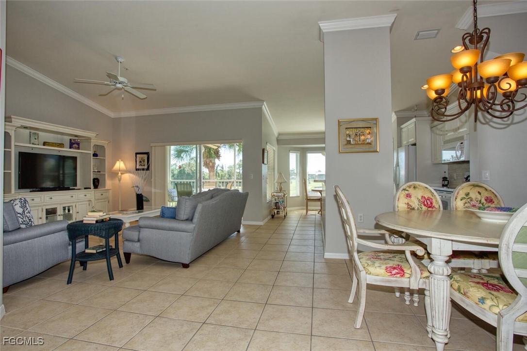 10371 McArthur Palms Lane, Unit 2823 Fort Myers, FL 33966 - Photo 6 of 48 a living room with furniture a flat screen tv and a floor to ceiling window