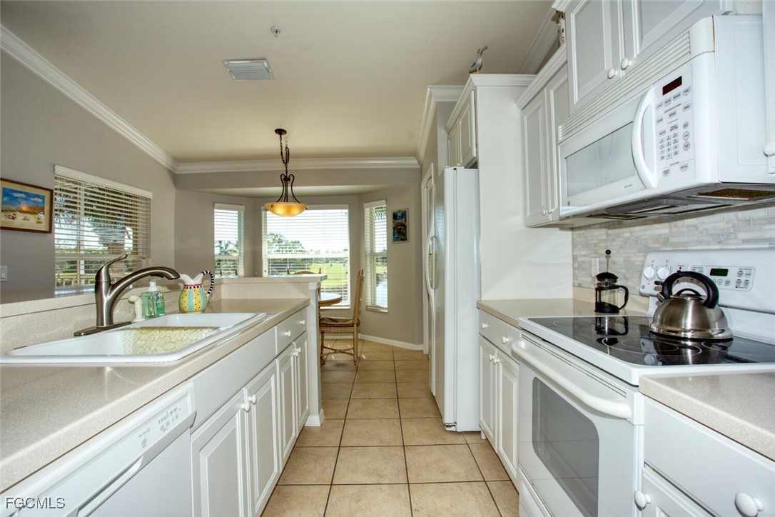 10371 McArthur Palms Lane, Unit 2823 Fort Myers, FL 33966 - Photo 10 of 48 a kitchen with a sink and a stove top oven