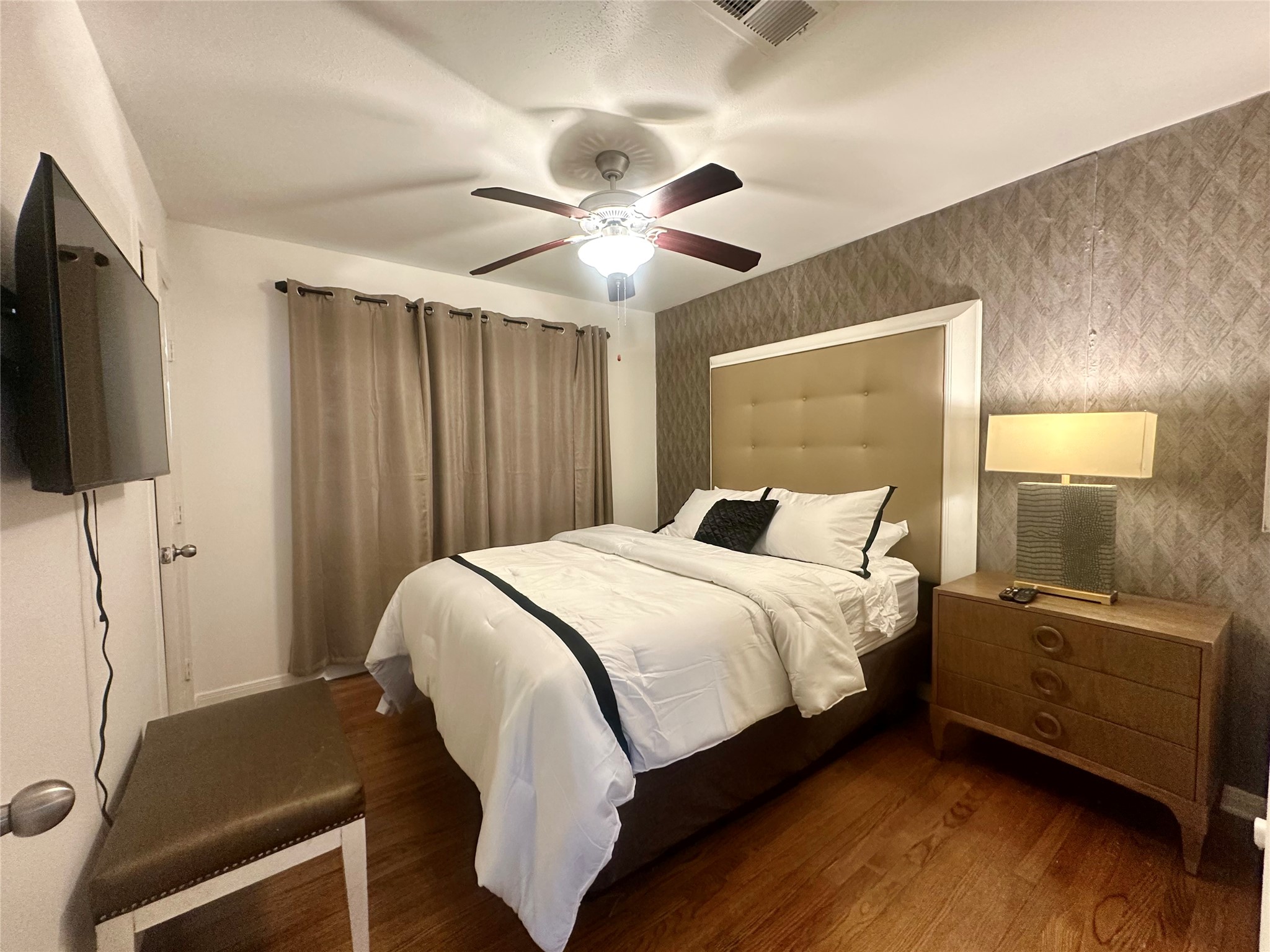 5329 Pagewood Lane Houston, TX 77056 - Photo 12 of 18 a bedroom with a bed and a flat tv screen on the dresser