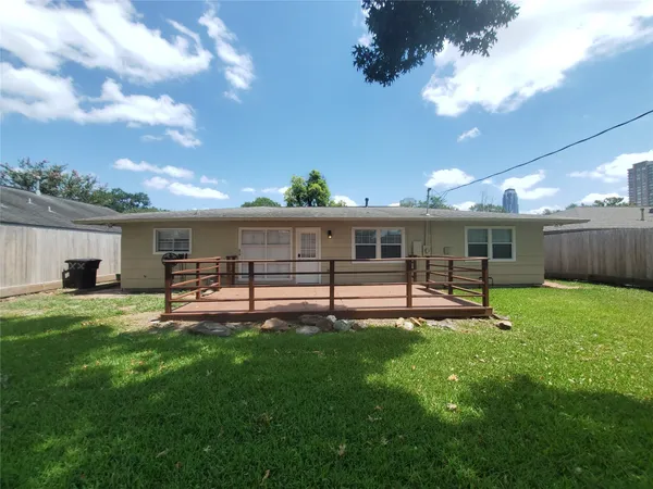 a view of an house with backyard and a tree