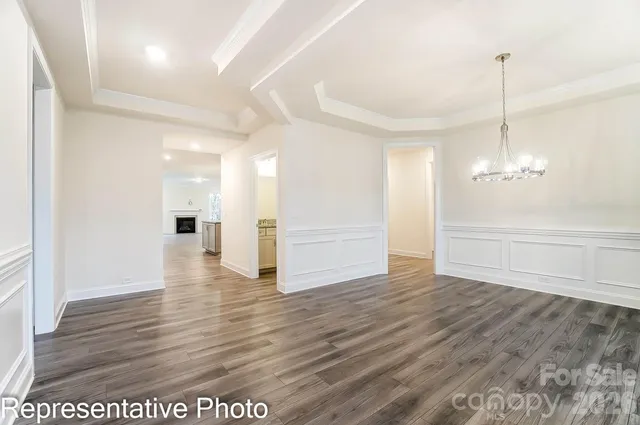 a view of a room with wooden floor staircase and a kitchen