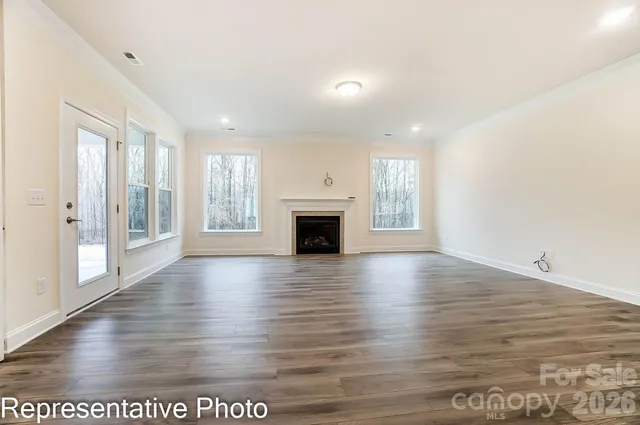an empty room with wooden floor and fireplace
