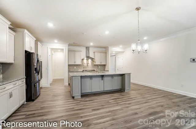 a large kitchen with granite countertop a large counter top appliances and cabinets