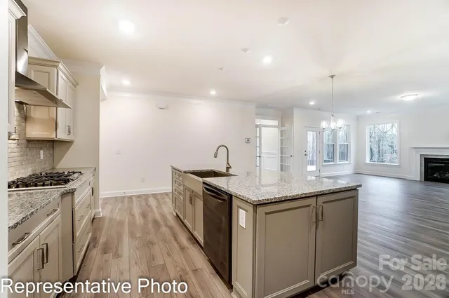 a kitchen with a sink and wooden floor