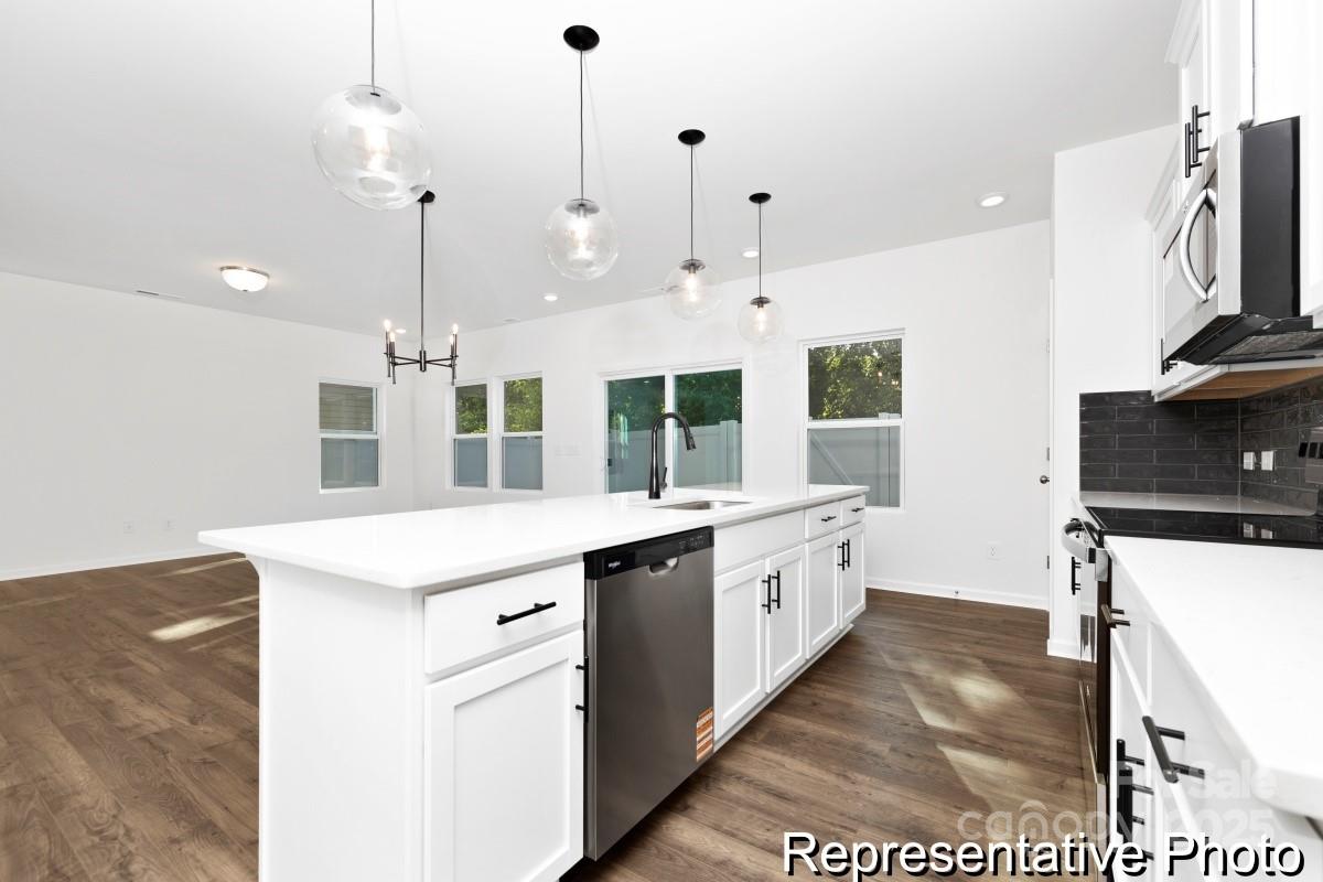 1015 Gondola Court, Unit 21AP Salisbury, NC 28146 - Photo 6 of 22 a large kitchen with stainless steel appliances kitchen island granite countertop a sink a stove and a refrigerator