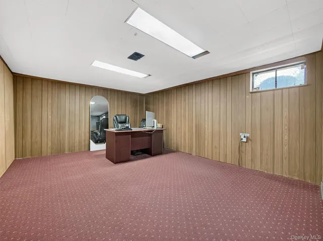 a view of a livingroom with workspace and a window