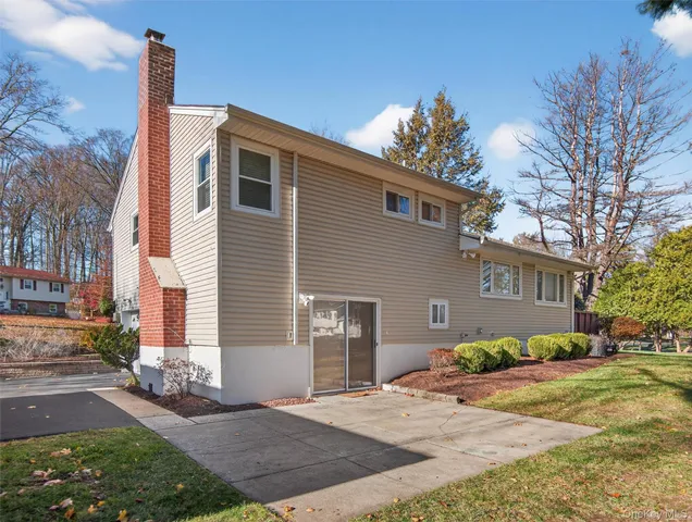 a view of a house with backyard and sitting area