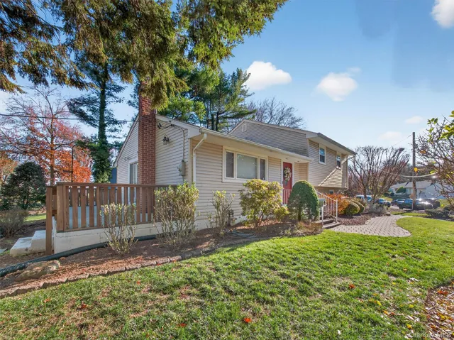 a front view of a house with yard and green space