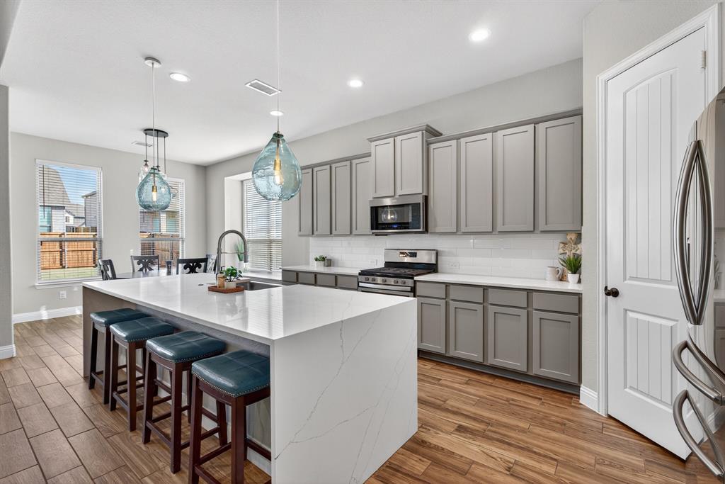 2815 Long Slope Road Arlington, TX 76001 - Photo 12 of 34 a kitchen with stainless steel appliances granite countertop a sink a stove a refrigerator cabinets and chairs