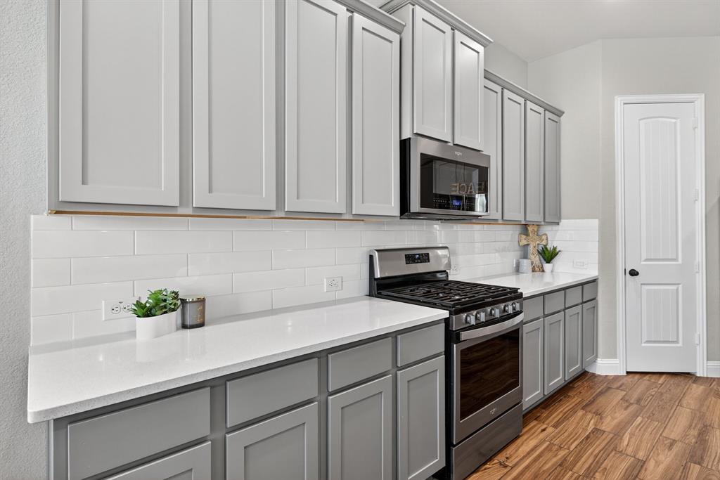 2815 Long Slope Road Arlington, TX 76001 - Photo 15 of 34 a kitchen with granite countertop a sink a stove and cabinets