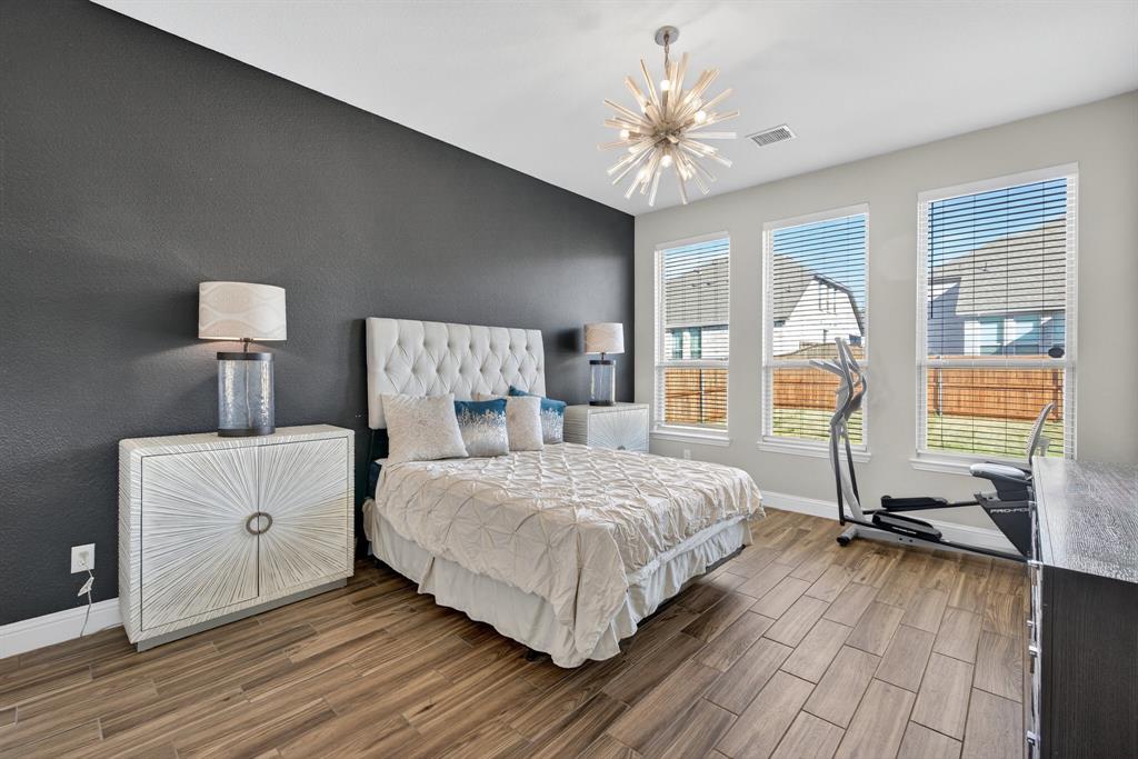 2815 Long Slope Road Arlington, TX 76001 - Photo 18 of 34 a bedroom with a bed and a chandelier