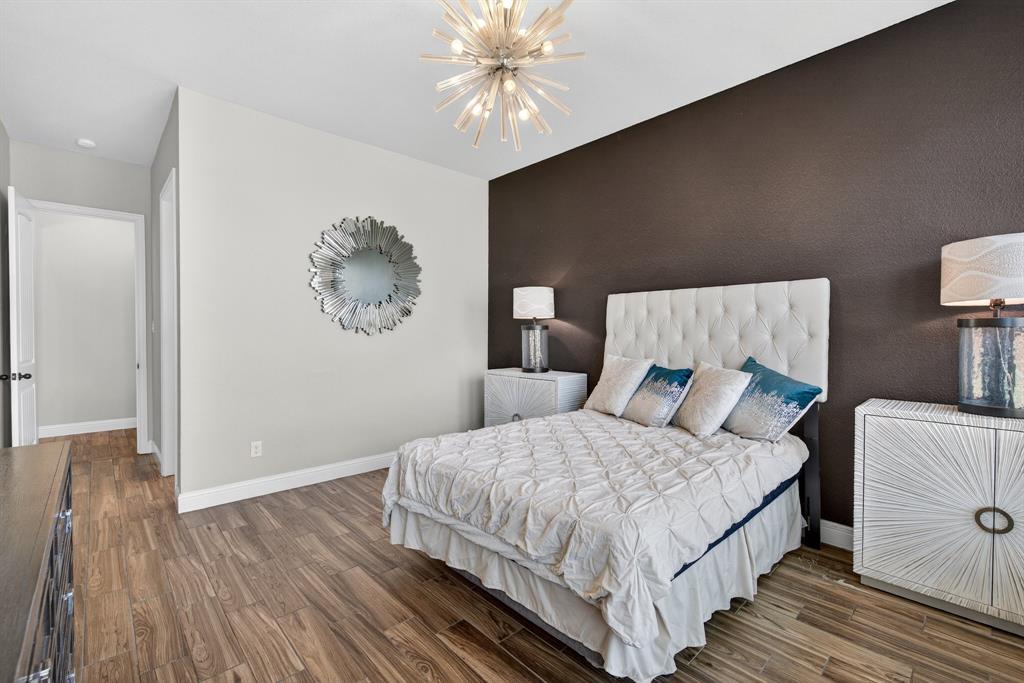 2815 Long Slope Road Arlington, TX 76001 - Photo 19 of 34 a bedroom with a bed and a chandelier