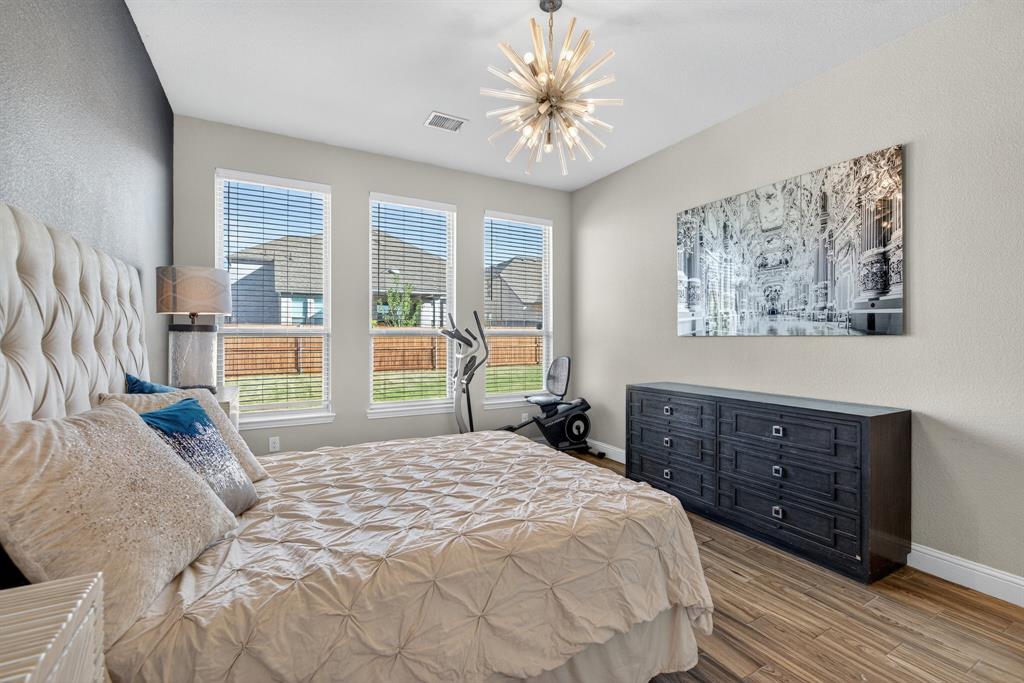 2815 Long Slope Road Arlington, TX 76001 - Photo 20 of 34 a bedroom with a bed a dresser and a large window