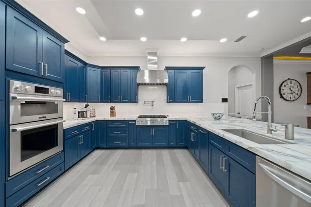 a kitchen with stainless steel appliances granite countertop wooden cabinets sink and stove top oven