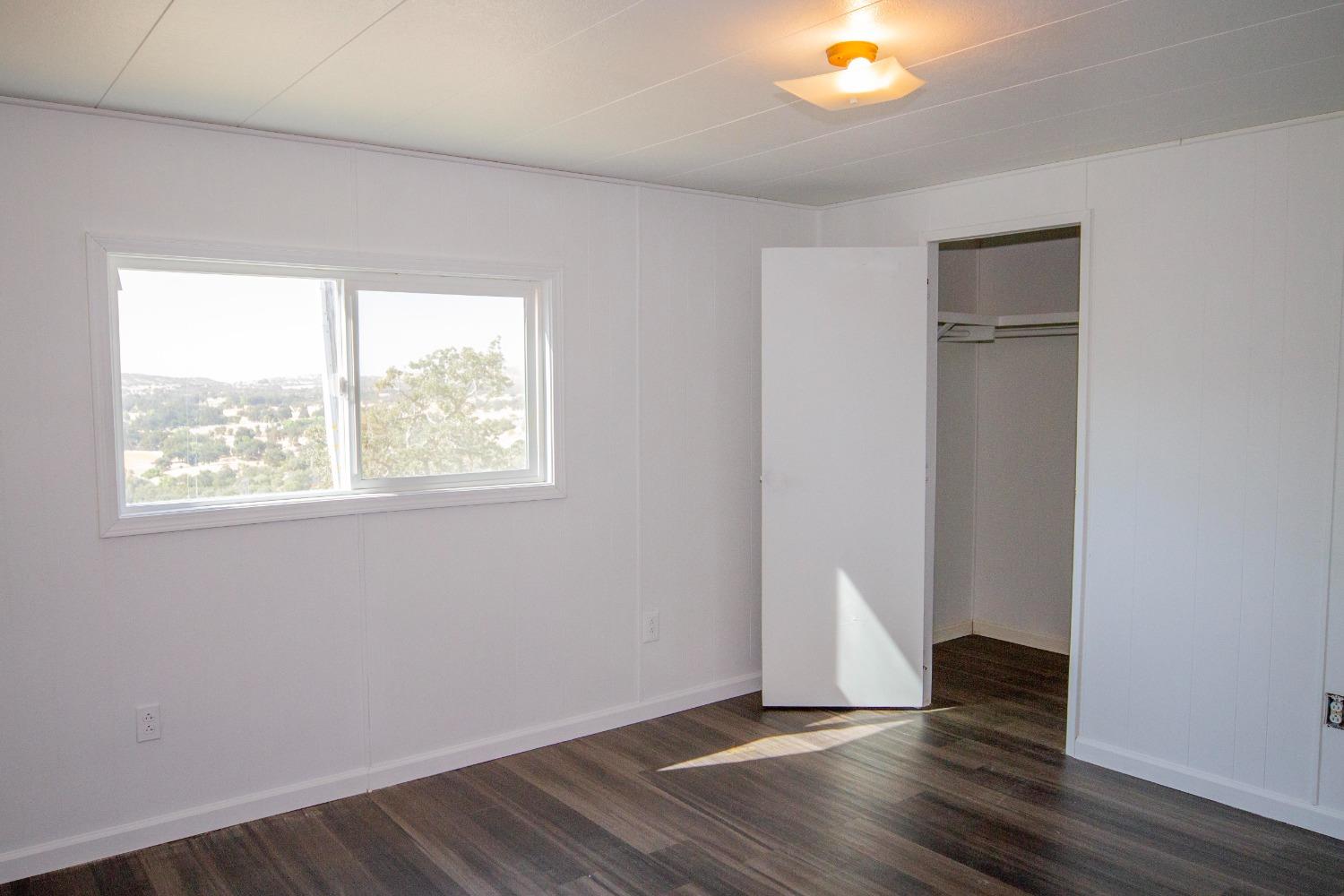 893 Winter Road Squaw Valley, CA 93675 - Photo 7 of 42 a view of an empty room with wooden floor and a window
