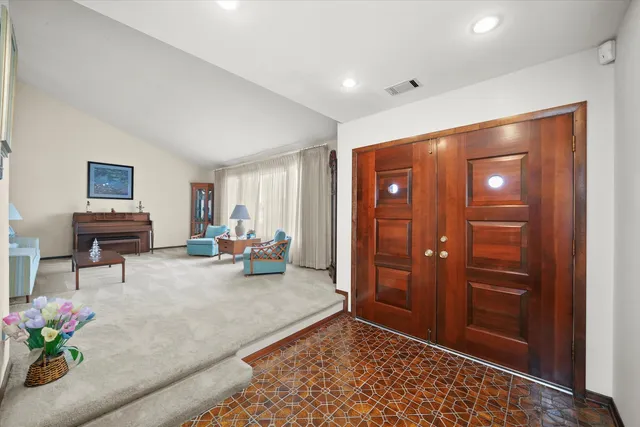 a dining room with furniture a chandelier and window