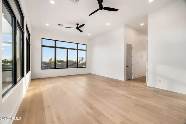 a view of an empty room with a window and a kitchen view