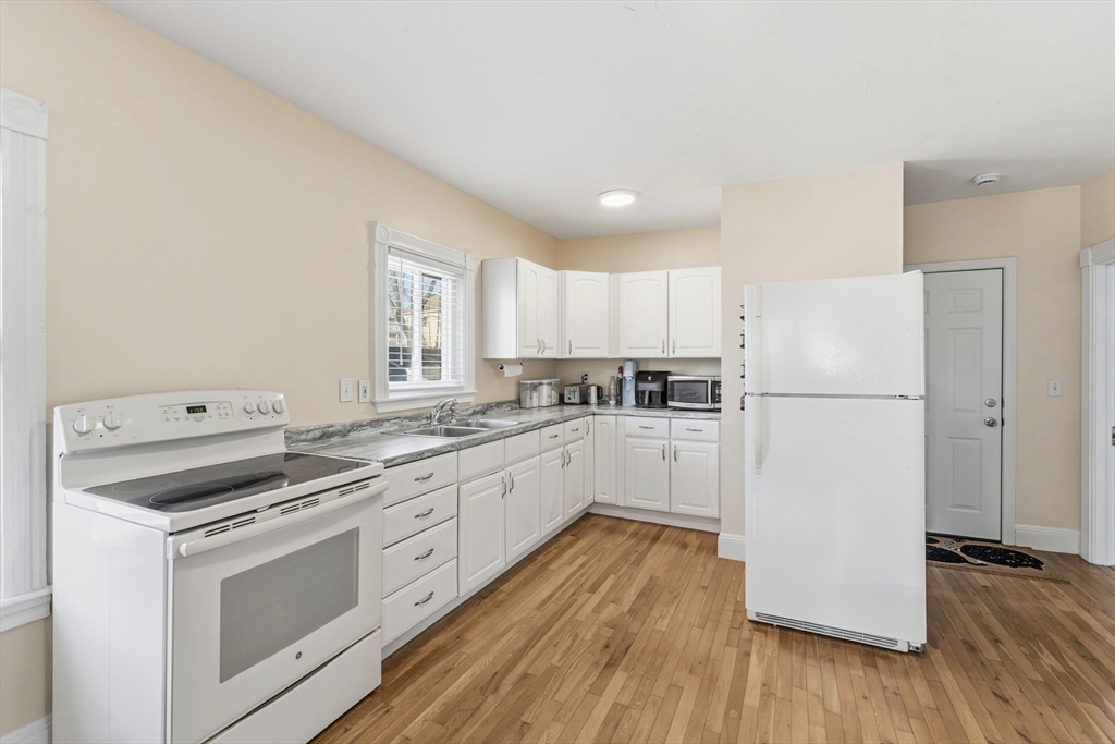 17 Cutler Street, Unit 1 Webster, MA 01570 - Photo 9 of 33 a kitchen with cabinets appliances wooden floor and a window