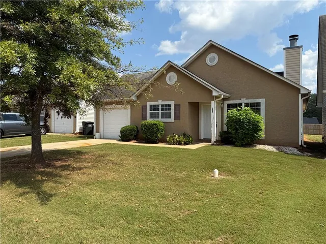a front view of a house with a garden